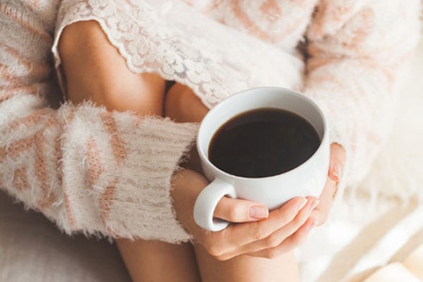 A Woman Holding a Warm Cup of Coffee