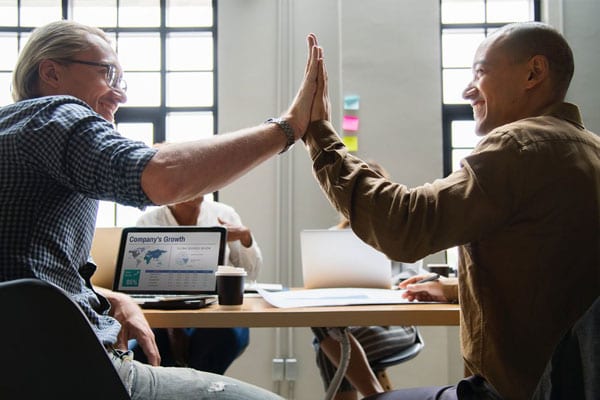 Two People High-Fiving Each Other