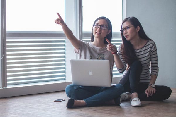 Two Women Discussing and Pointing at Something