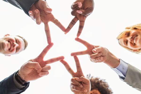 A Group of Friends Forming a Star Using Their Fingers