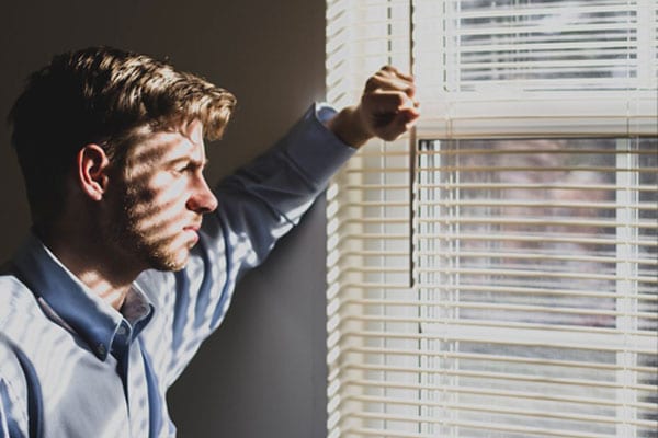 A Man Looking Through His Window